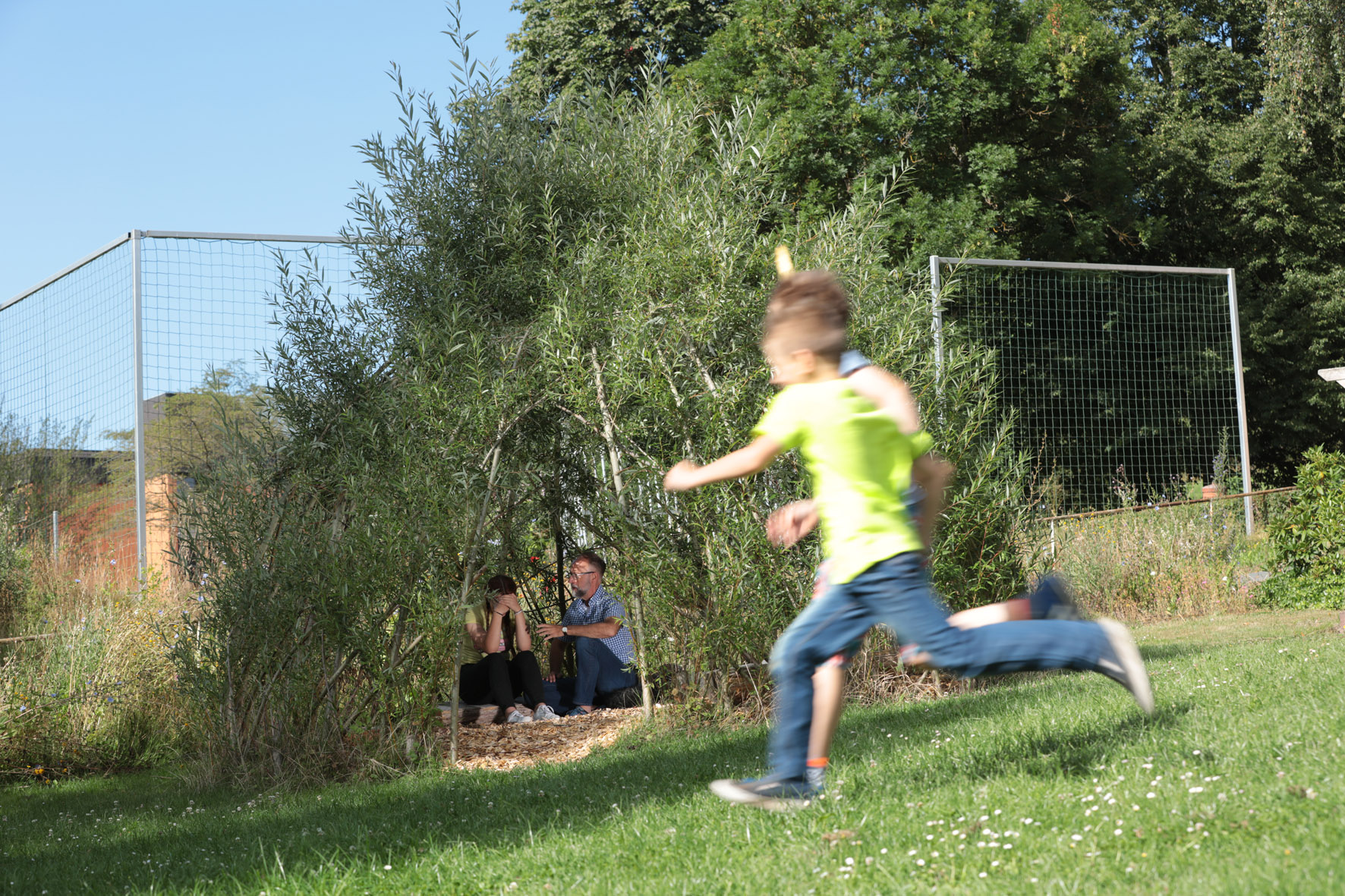 Spielende Kinder toben über die Wiese