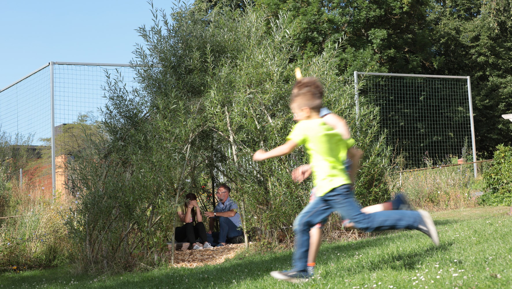 Spielende Kinder toben über die Wiese